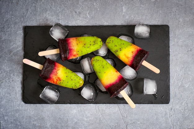 Colorful layer ice cream on a stick made from natural fruit. Top view