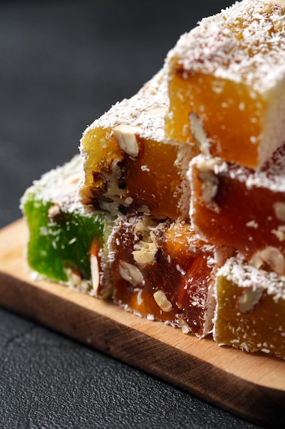 colorful layers of traditional sweet treat made with nuts and fruit flavors served on wooden board