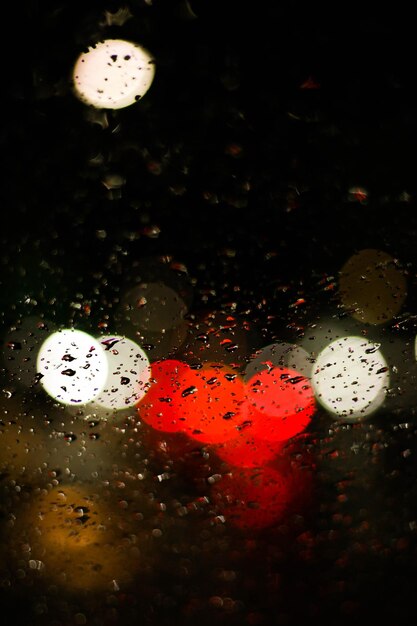 Photo colorful lights seen through wet window glass at night