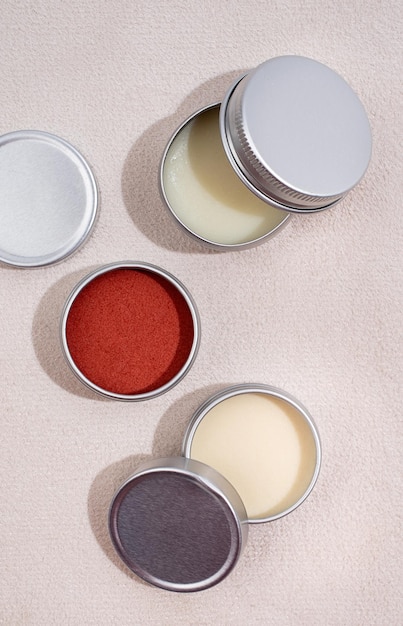 Colorful lip balms in round tin cases on leather background with shadow overlay mockup design