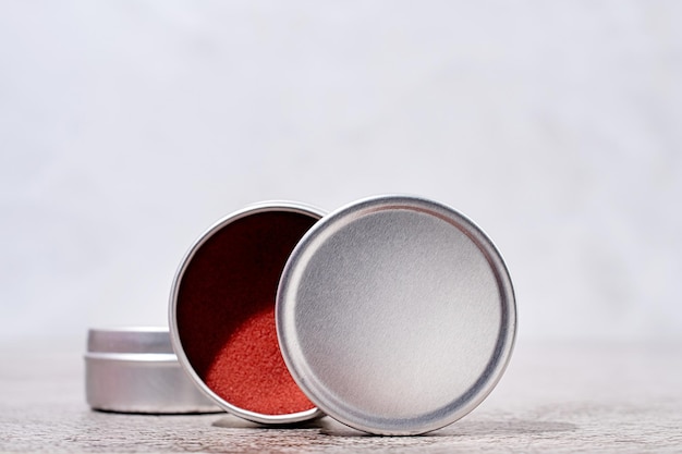 Photo colorful lip balms in round tin cases on light background with shadow overlay mockup design label