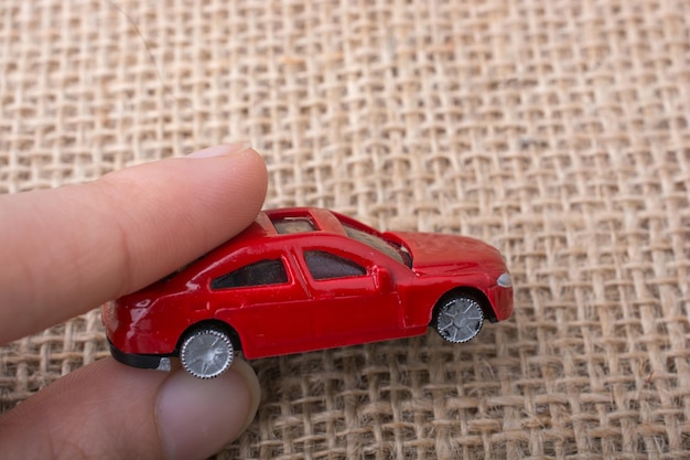 Colorful little toy car in hand on white background