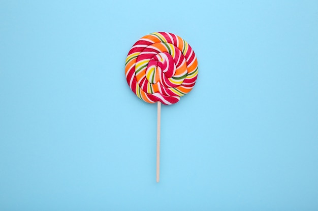 Colorful lollipop on a blue background, sweet candy.