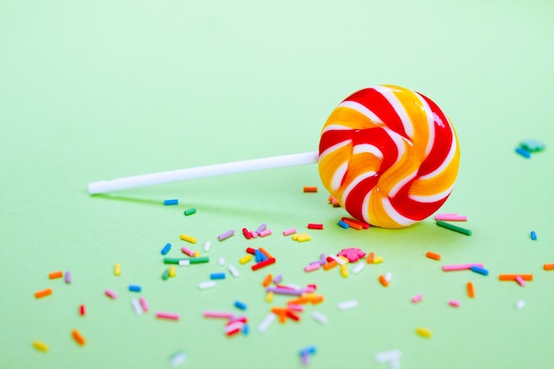 Colorful lollipop and confetti on green background. Sweets for party