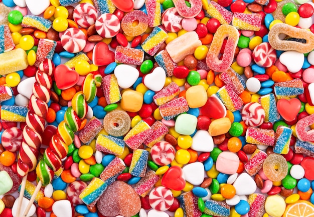 Colorful lollipops and different colored round candy Top view