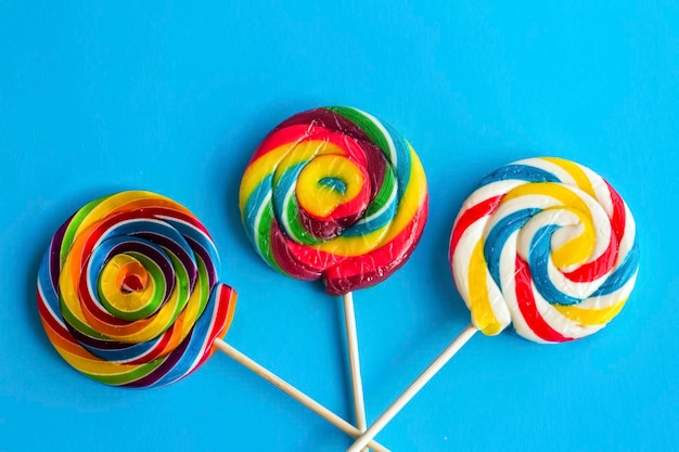 Красочные леденцы на палочке и разноцветные круглые конфеты. Вид сверху.