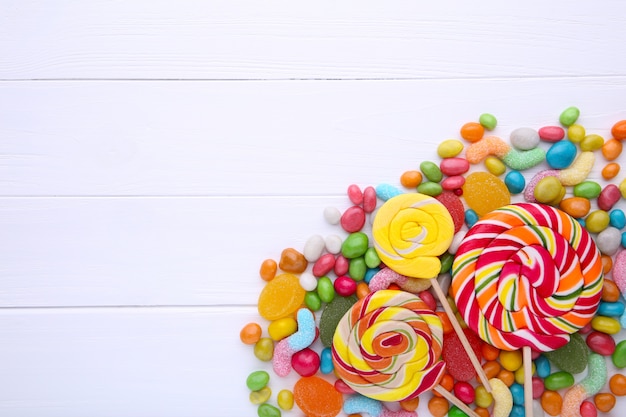 Colorful lollipops and different colored round candy on white background