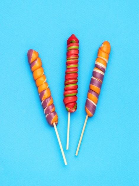 Colorful lollipops on sticks on a light blue background Minimal concept of sweet life and love