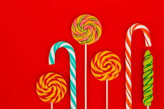 Colorful lollipops and sweets on a red background