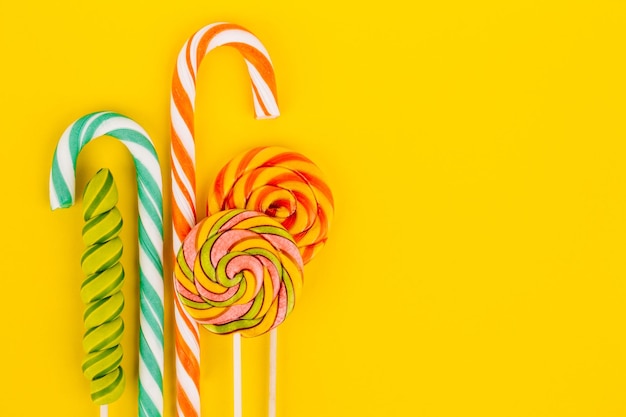 Colorful lollipops and sweets on a yellow background