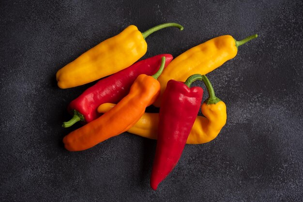 Colorful long sweet peppers on dark background