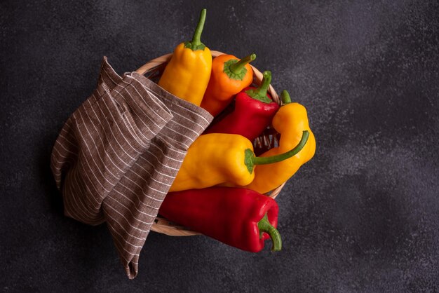 Colorful long sweet peppers on dark background