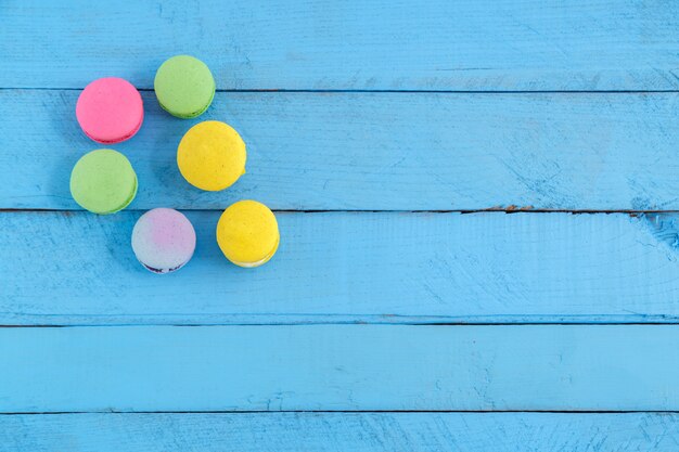 Colorful macaron cookies on blue wooden vintage table