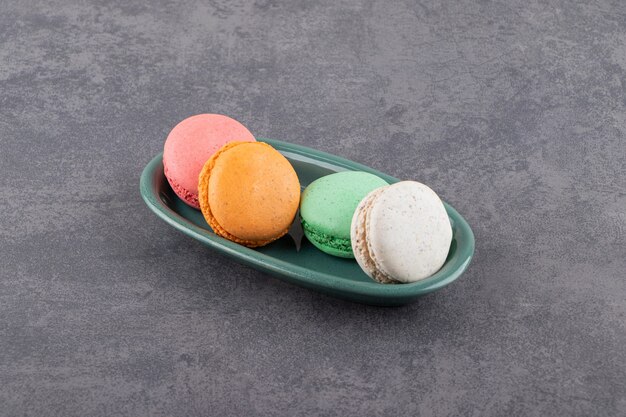 Colorful macarons dessert placed on a stone table .