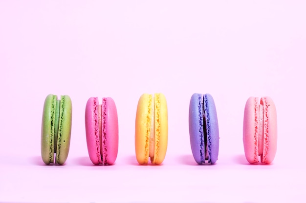 Colorful macarons on a pink background