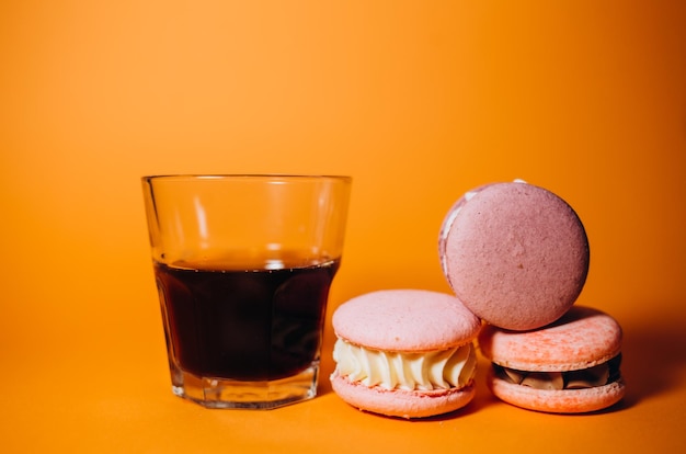 Colorful macaroons cookies and black coffee on a white table