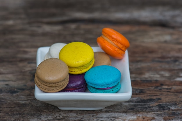 Colorful Macaroons in dish on wooden table