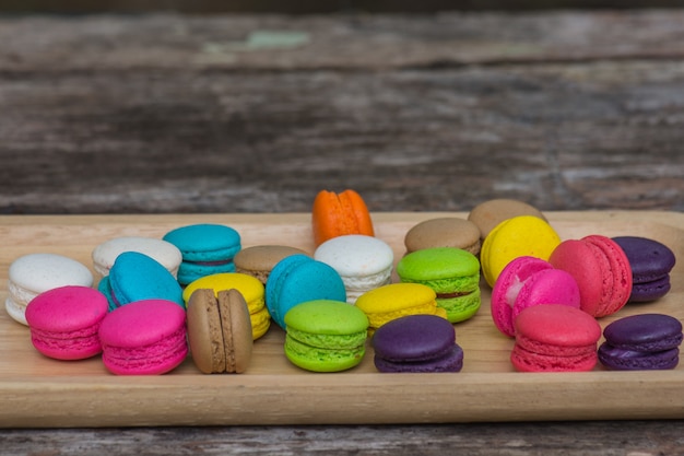 Colorful Macaroons in dish on wooden table