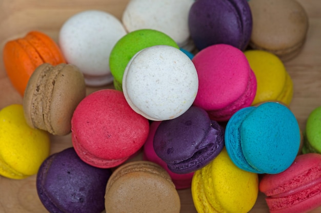 Photo colorful macaroons in dish on wooden table