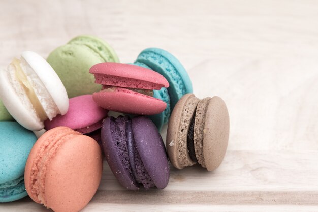 Colorful  macaroons in stack on light wooden background