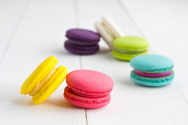 Colorful Macaroons on white wooden background.