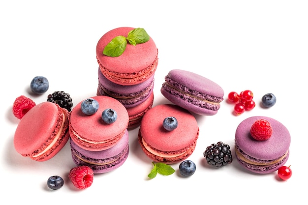 Colorful macaroons with berry fruits on white background