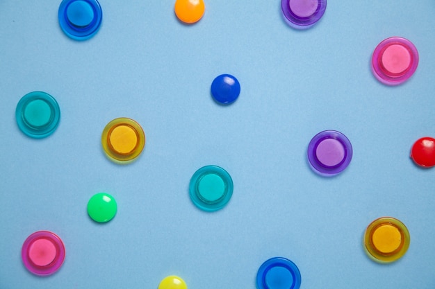 Colorful magnet plastic buttons on blue background.