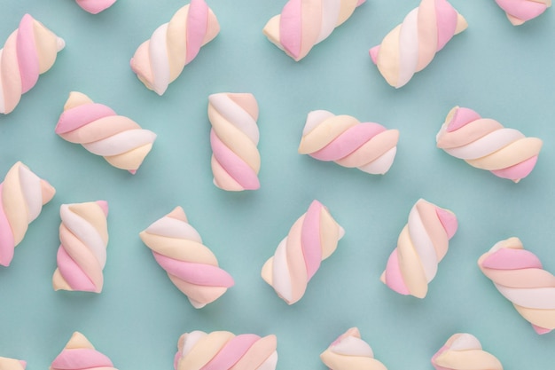 Colorful marshmallow laid out on pastel background. Creative textured pattern.