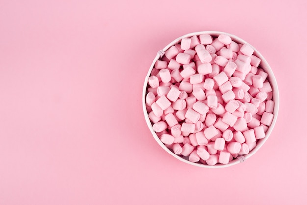 Colorful marshmallow laid out on pink paper surface