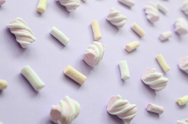 Colorful marshmallow laid out on violet paper background. 