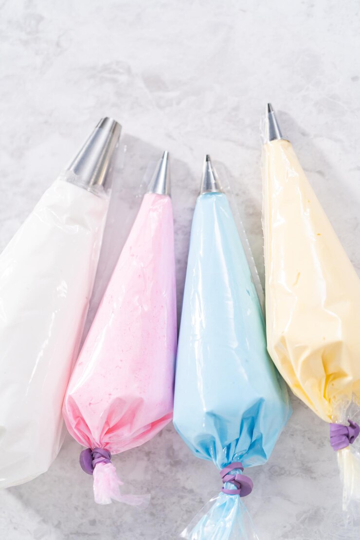 Photo colorful meringue in piping bags with metal piping tips