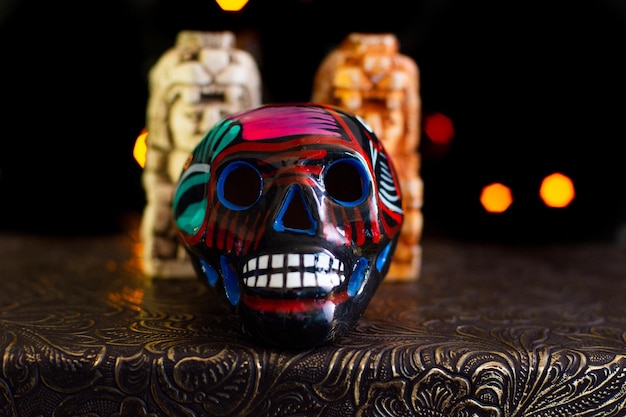 Colorful Mexican dia de muertos ceramic skull on black background with lights