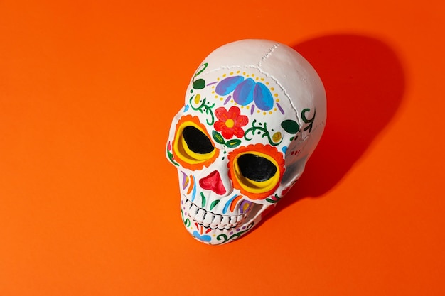 Colorful mexican skull on orange background close up