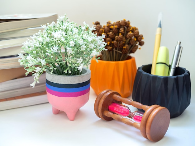 Photo colorful modern concrete planter with flower hourglass and books