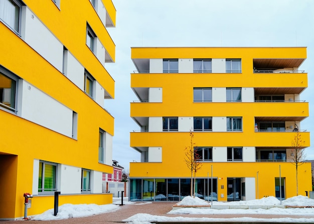 Colorful Modern residential apartment and flat building exterior in Salzburg, Austria. New luxury house and home complex of yellow color. City Real estate property and condo architecture.