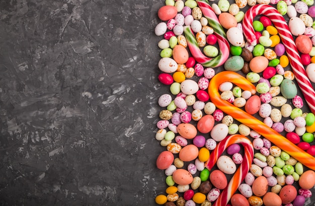 Colorful multicolored candies on black concrete 