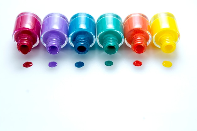 Colorful nail polish bottles on white, copy space