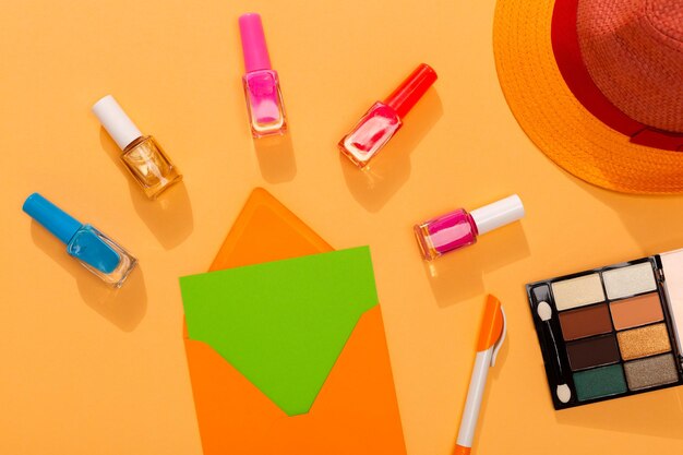 Colorful nail polish for summer on orange background with blank envelope and free space for text