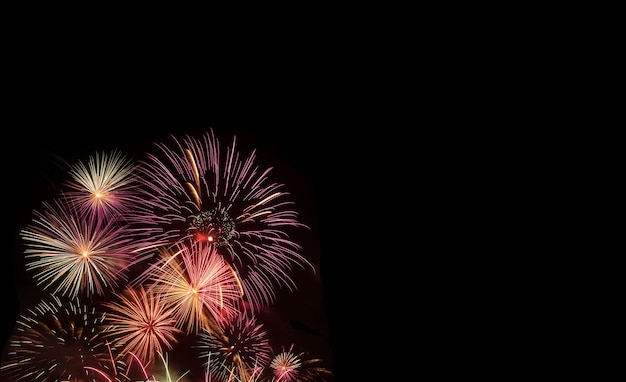 Colorful new year holiday fireworks on black background with copy space