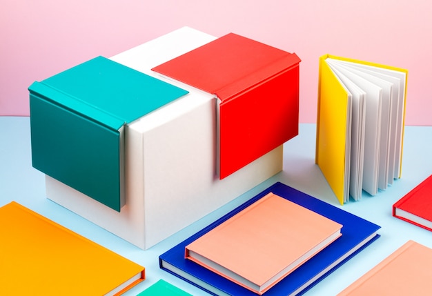 Photo colorful notebooks over the blue pastel background. modern abstract working space