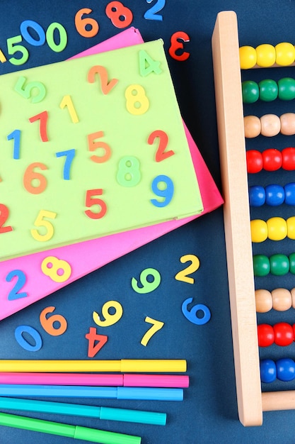 Colorful numbers abacus books and markers on school desk background