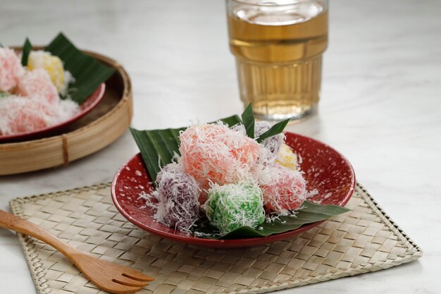 Photo colorful ongol ongol or sentiling steamed cassava cake coating with grated coconut