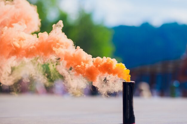 Colorful orenge smoke bombs in action