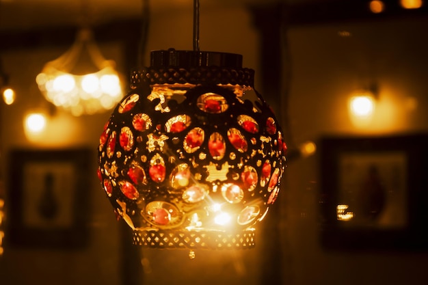 Colorful orient lamp through window on Chinese restaurant Arabic mystery lantern shining in the cafe Lights of big city Atmosphere of comfort and celebration Selective focus Blurred background