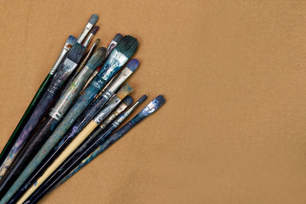 Colorful paintbrushes on brown background