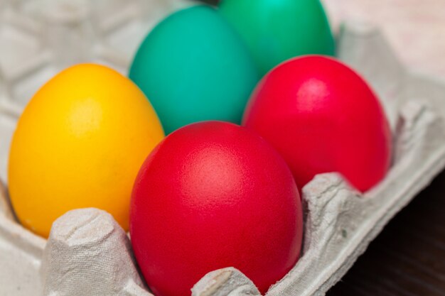 Colorful painted eggs for Easter in a paper box