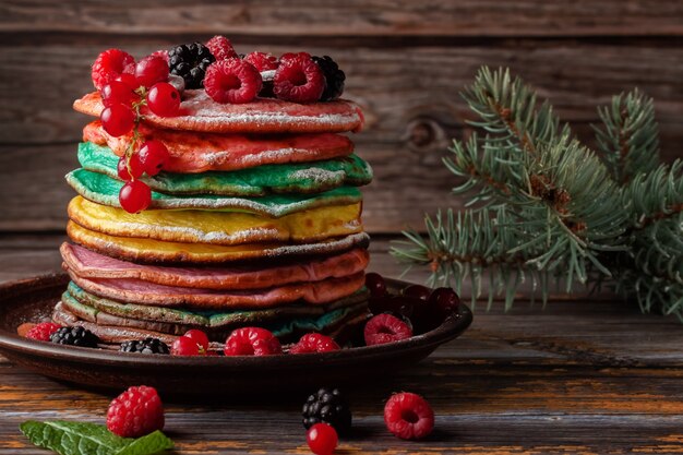 Colorful pancakes with fruits and powdered sugar