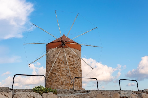 Photo colorful panoramic view of windmills with yachts in mandraki harbor at sunset rhodes greece