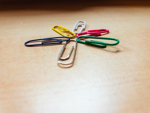 Colorful paper clips on wooden table