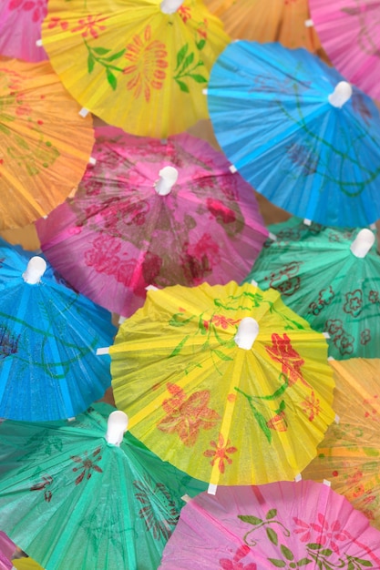 Colorful paper cocktail umbrella close-up as background